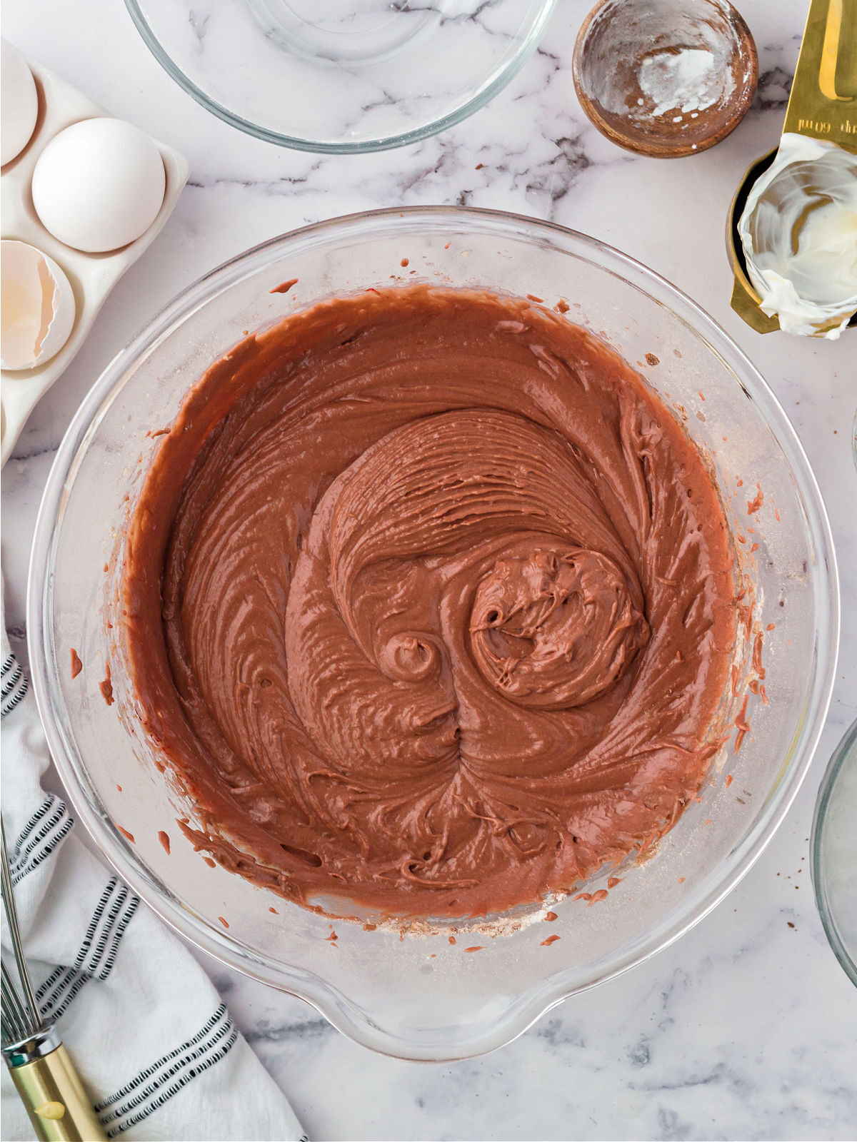 Red velvet cake batter in a glass mixing bowl.