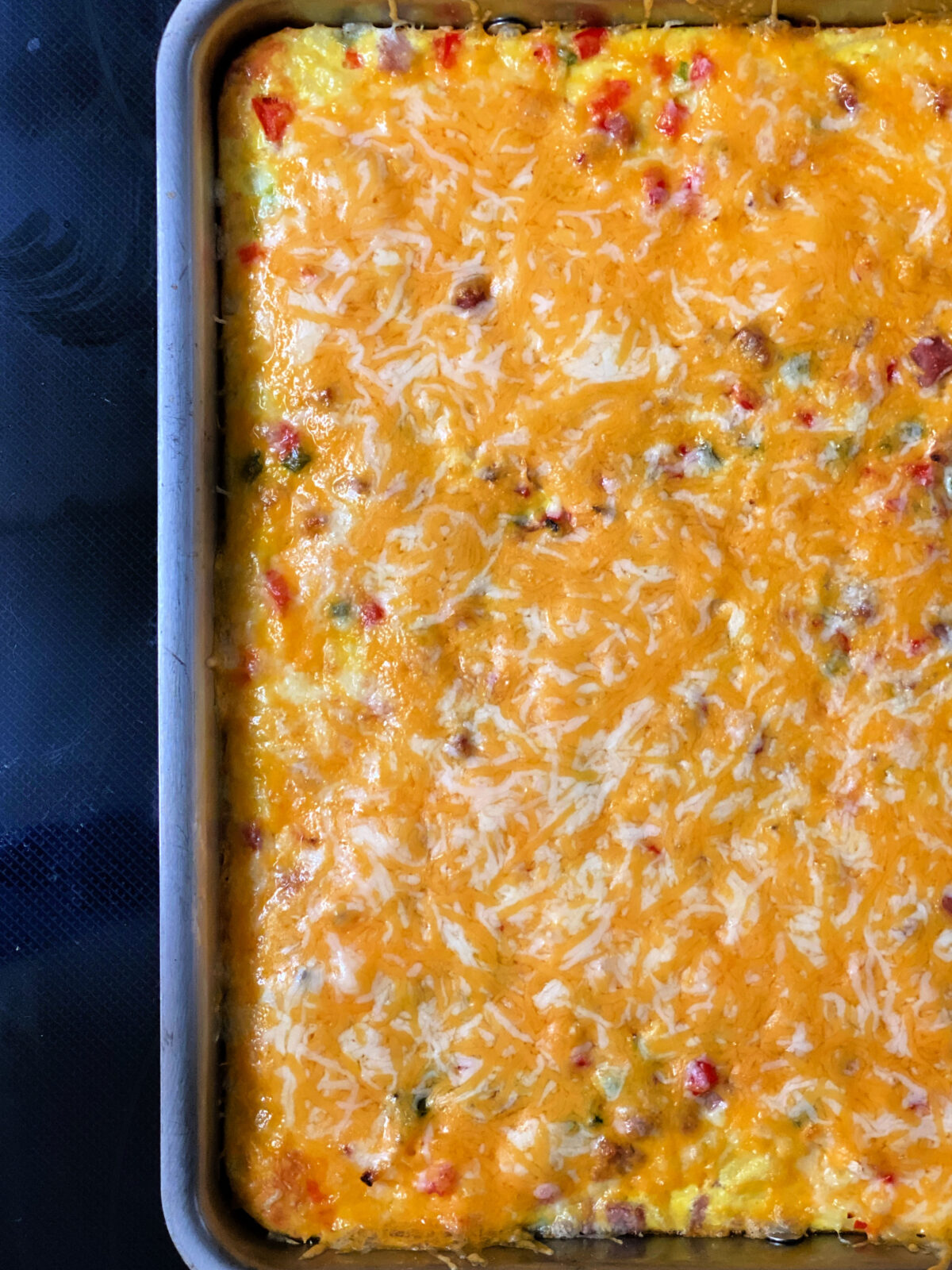 Baked breakfast casserole topped with Pepper Jack cheese.