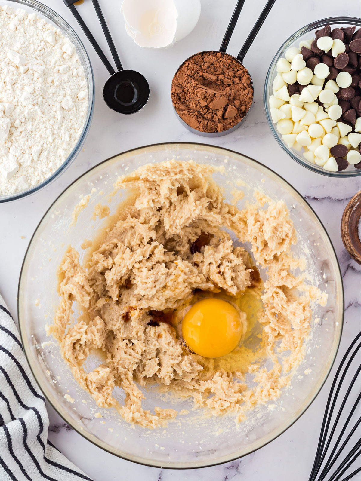 Adding an egg to creamed sugar mixture.