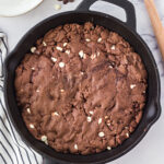 Baked triple chocolate pizookie in a cast iron skillet.