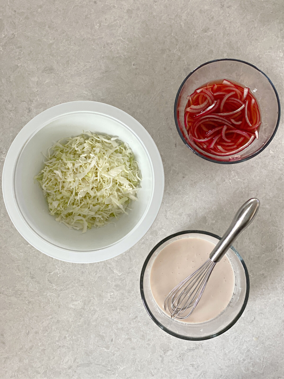 Shredded cabbage, Greek yogurt dressing, and pickled onions.