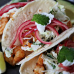 Air fried shrimp tacos with pickled red onions, cilantro slaw, and dollop of Greek yogurt.