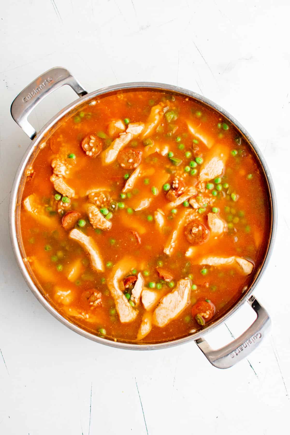 Paella cooking in a skillet.