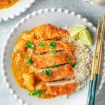 Plate with breaded chicken cutlet, rice, and curry sauce.