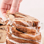 Man picking up a slice of cinnamon bread.