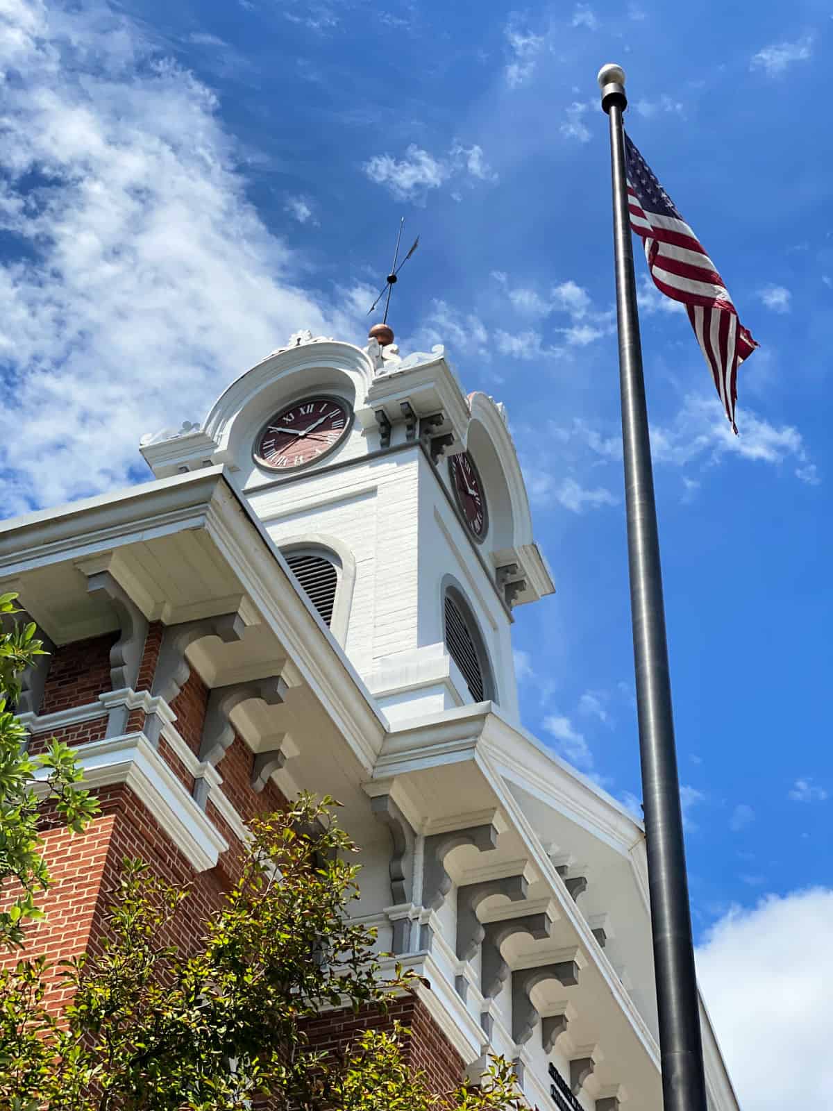 Clock on top of a building and an American flag.