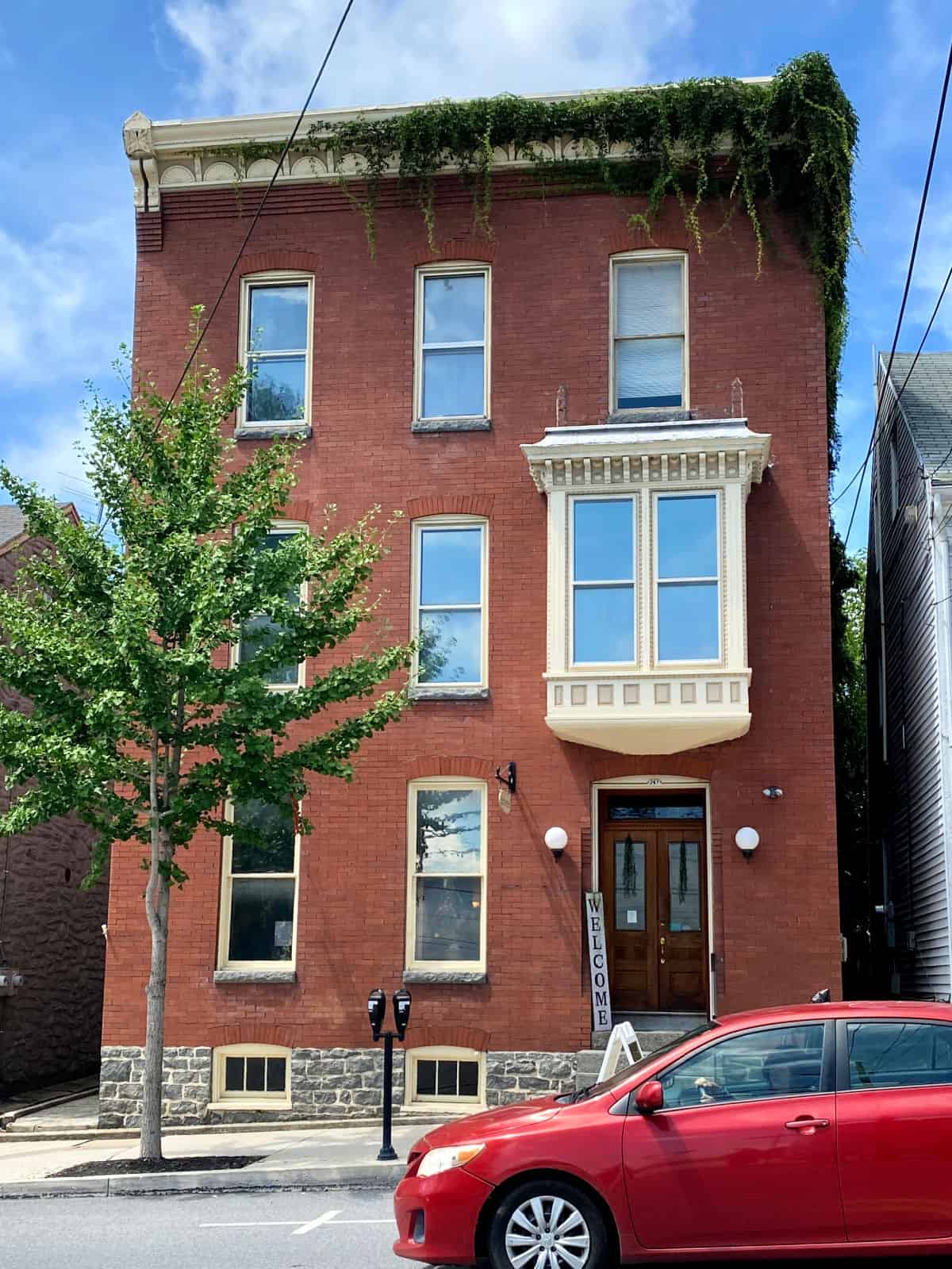 Red brick building with large white window.