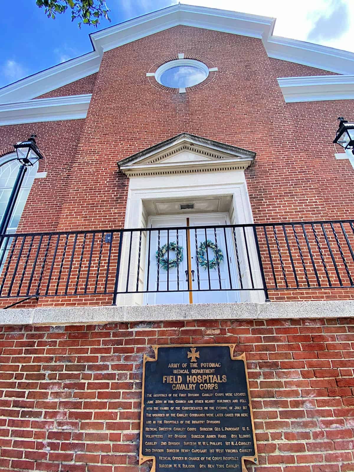 Red brick church with double white doors.