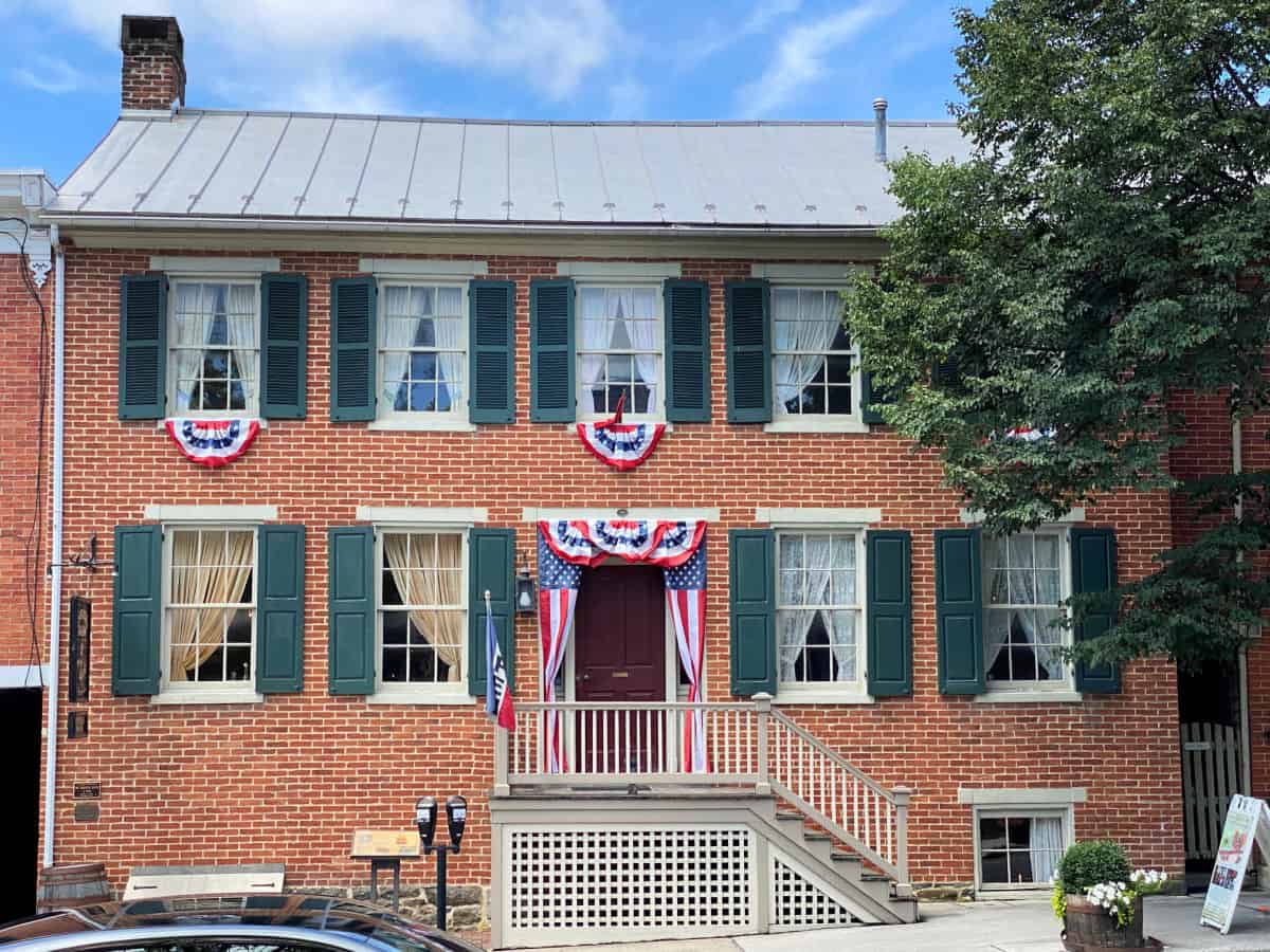 Red brick building with metal roof and decorated with American flags.