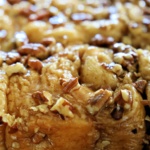 Sticky buns topped with caramel sauce and chopped pecans.