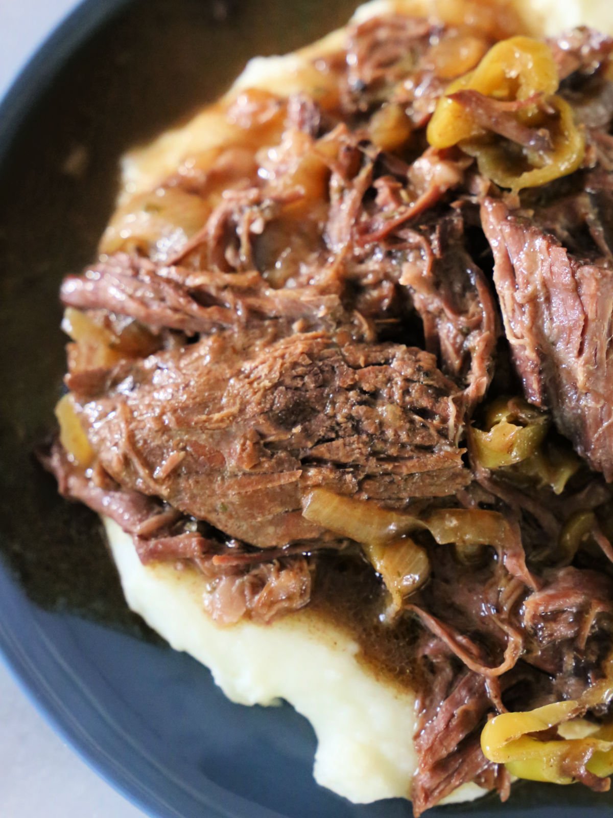 Plate with mashed potatoes topped with Mississippi Pot Roast.