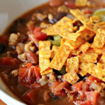 Bowl of taco soup topped with tortilla strips.