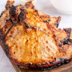Air fried pork chops on a wooden board.