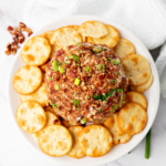 Cheeseball topped with pecans, bacon, everything bagel seasoning, and chives.