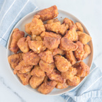 Chicken nuggets on a white plate.