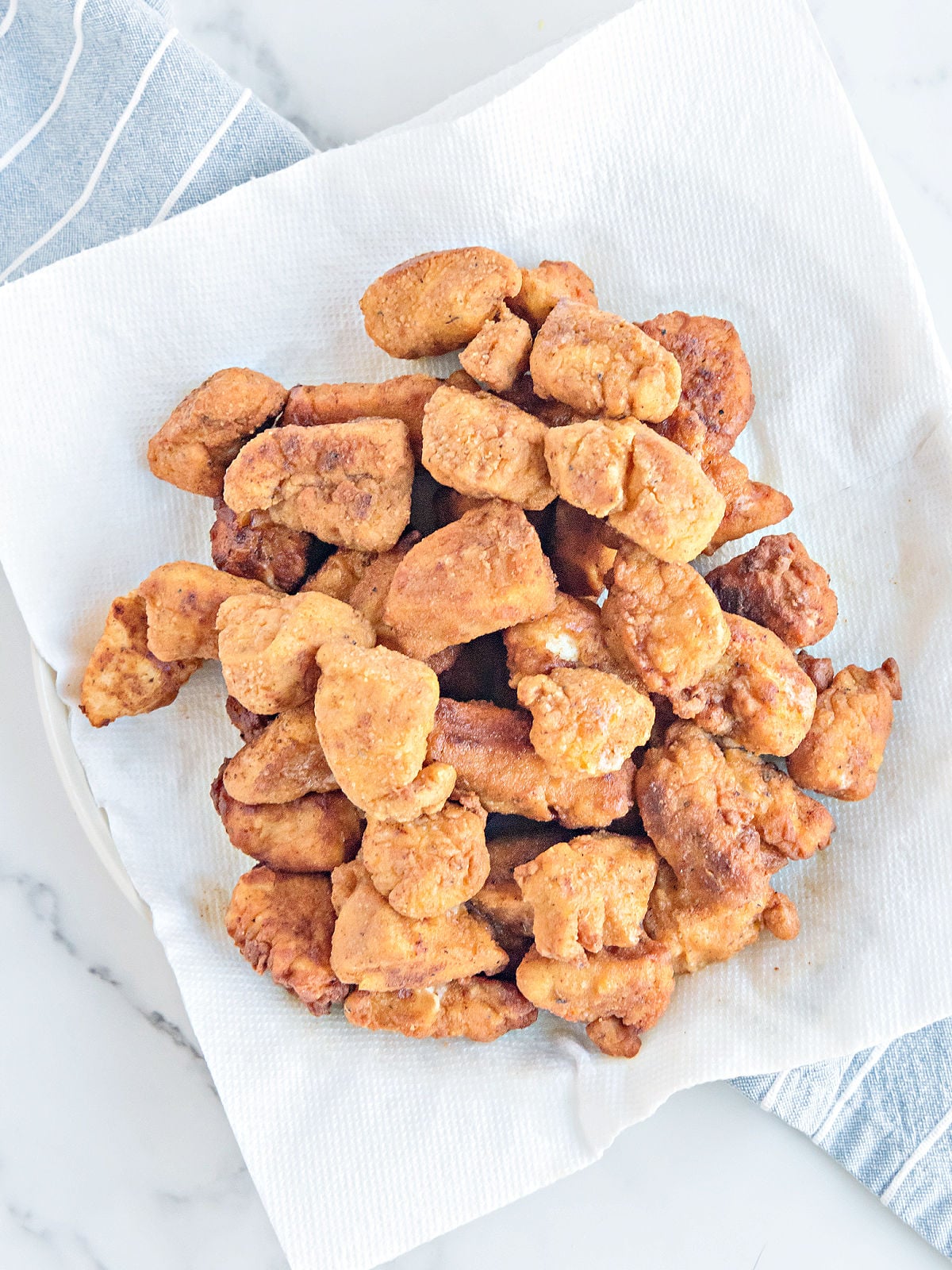 Chicken nuggets draining on a paper towel.
