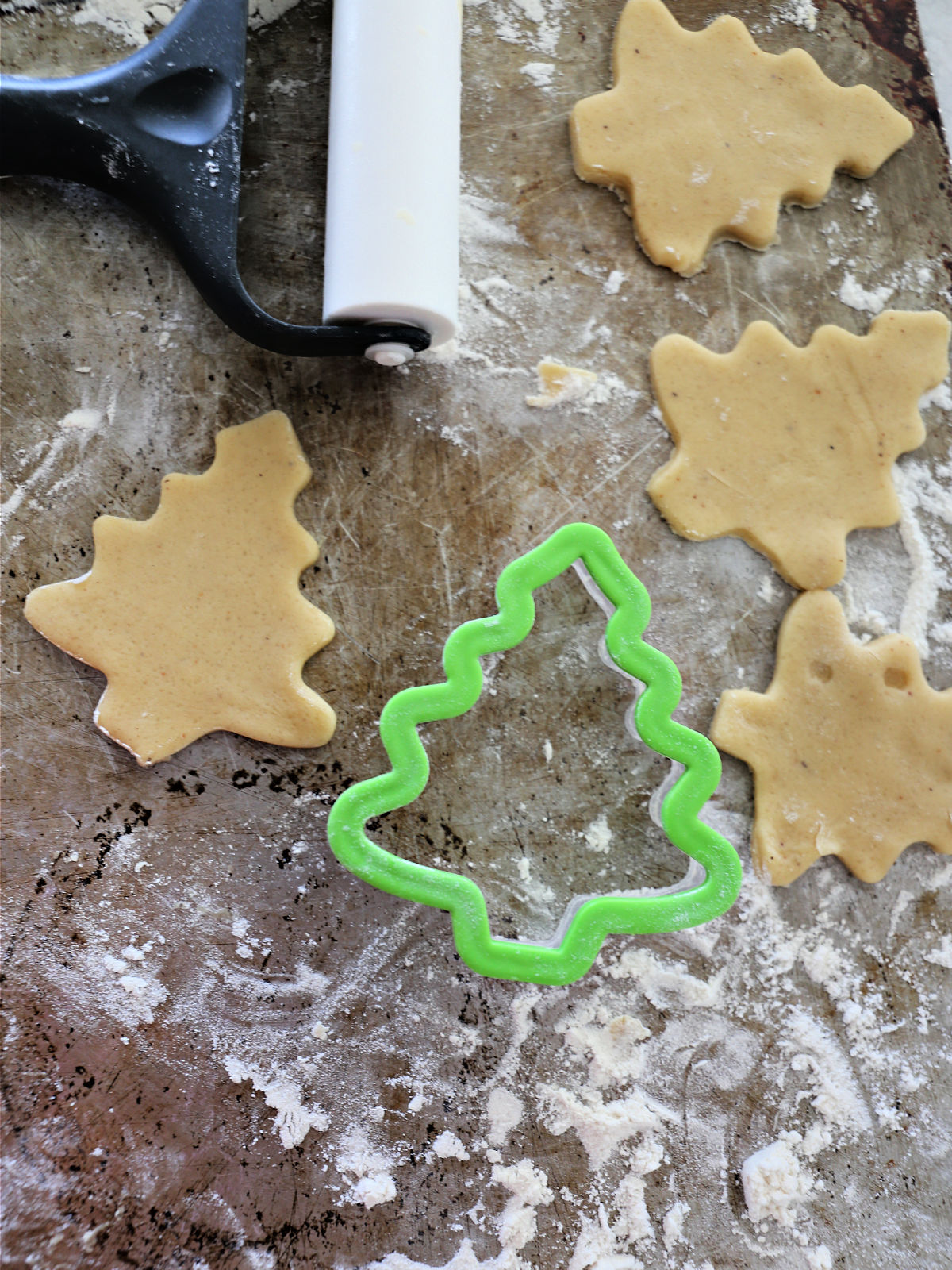 Christmas tree cookie cutter and cut out cookies.