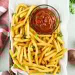 Platter of French fries and a bowl of ketchup.