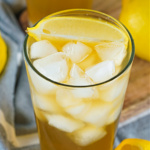 Glass filled with ice, lemonade, unsweetened tea, and bourbon and topped with a lemon wedge.