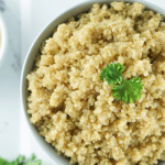 Cooked quinoa topped with parsley.