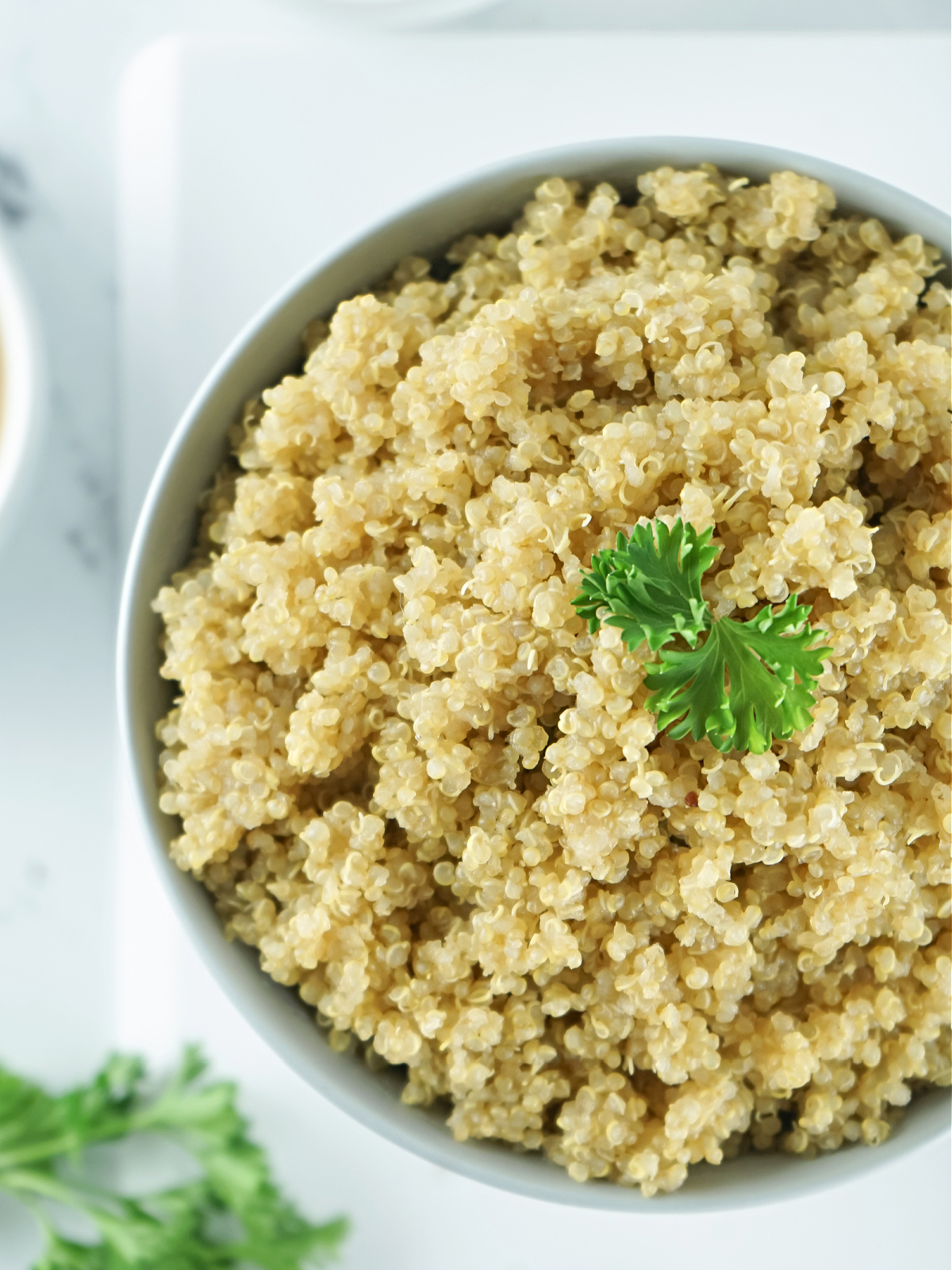 Cooked quinoa topped with parsley.