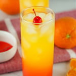 Tequila Sunrise cocktail topped with a cherry.