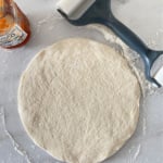 Pizza dough rolled into a 10-inch circle.