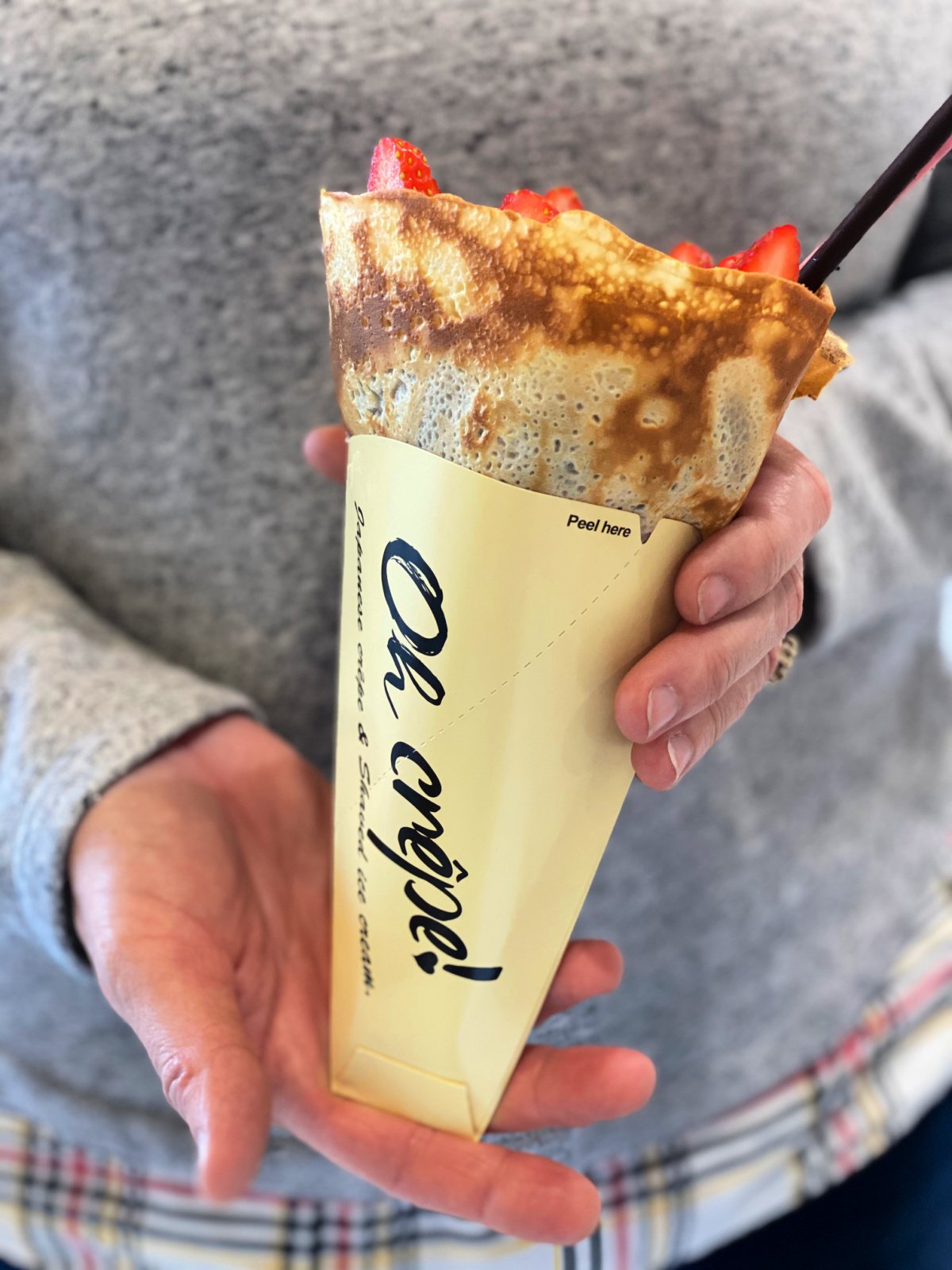 Woman holding a strawberry crepe.