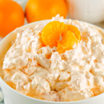 Bowl of orange fluff topped with a mandarin orange.