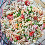 Bacon Ranch pasta salad with tomatoes, peas, and bacon.