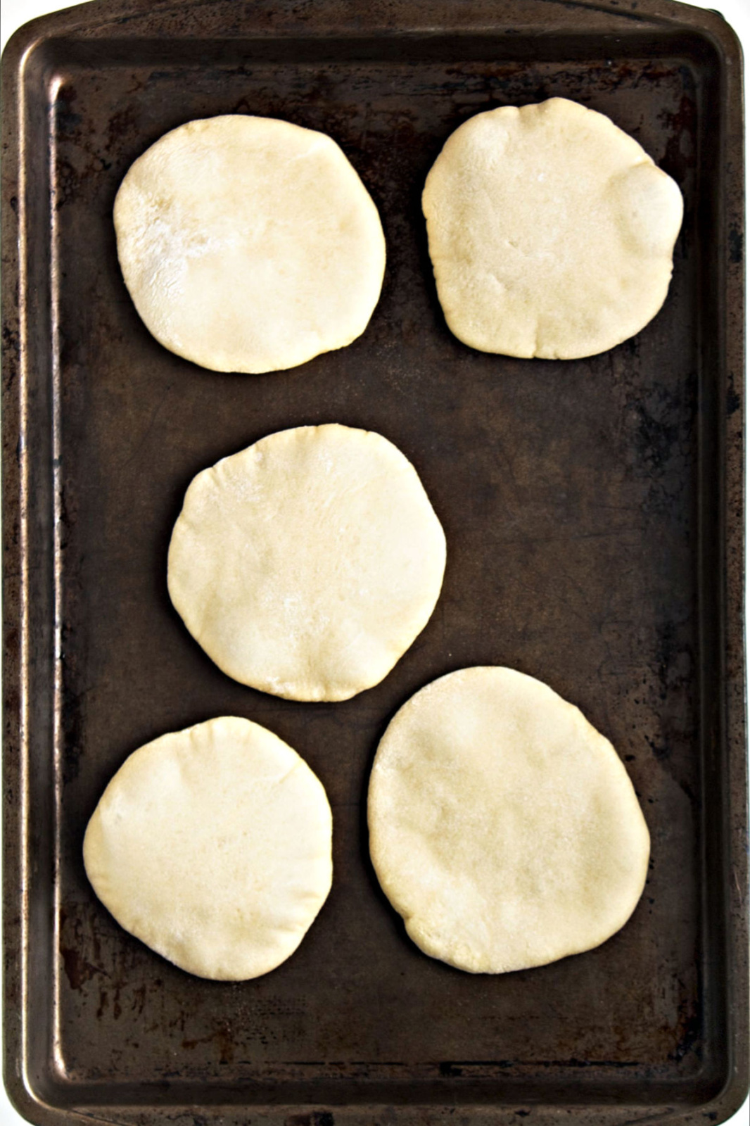 Pita bread on a baking sheet.