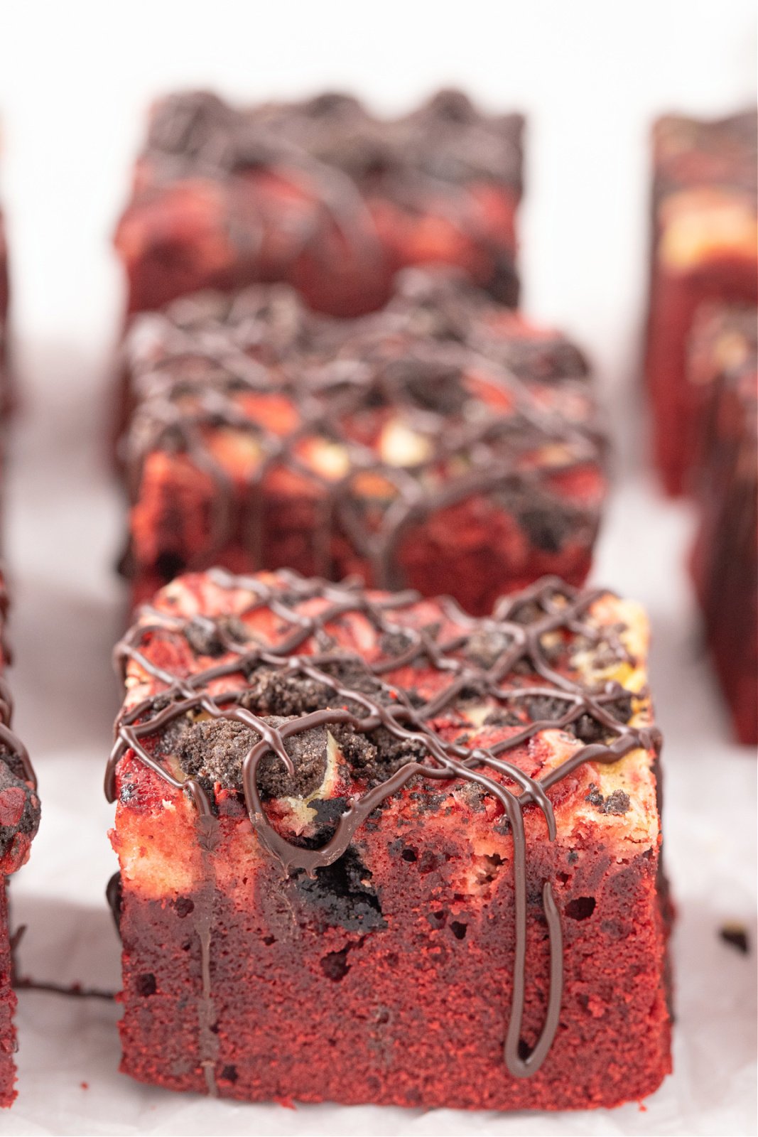 Red velvet brownies with Oreo cookies drizzled with chocolate.