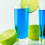 Blue Kamikaze shot topped with a lime slice.