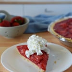 Slice of strawberry pie with whipped cream.