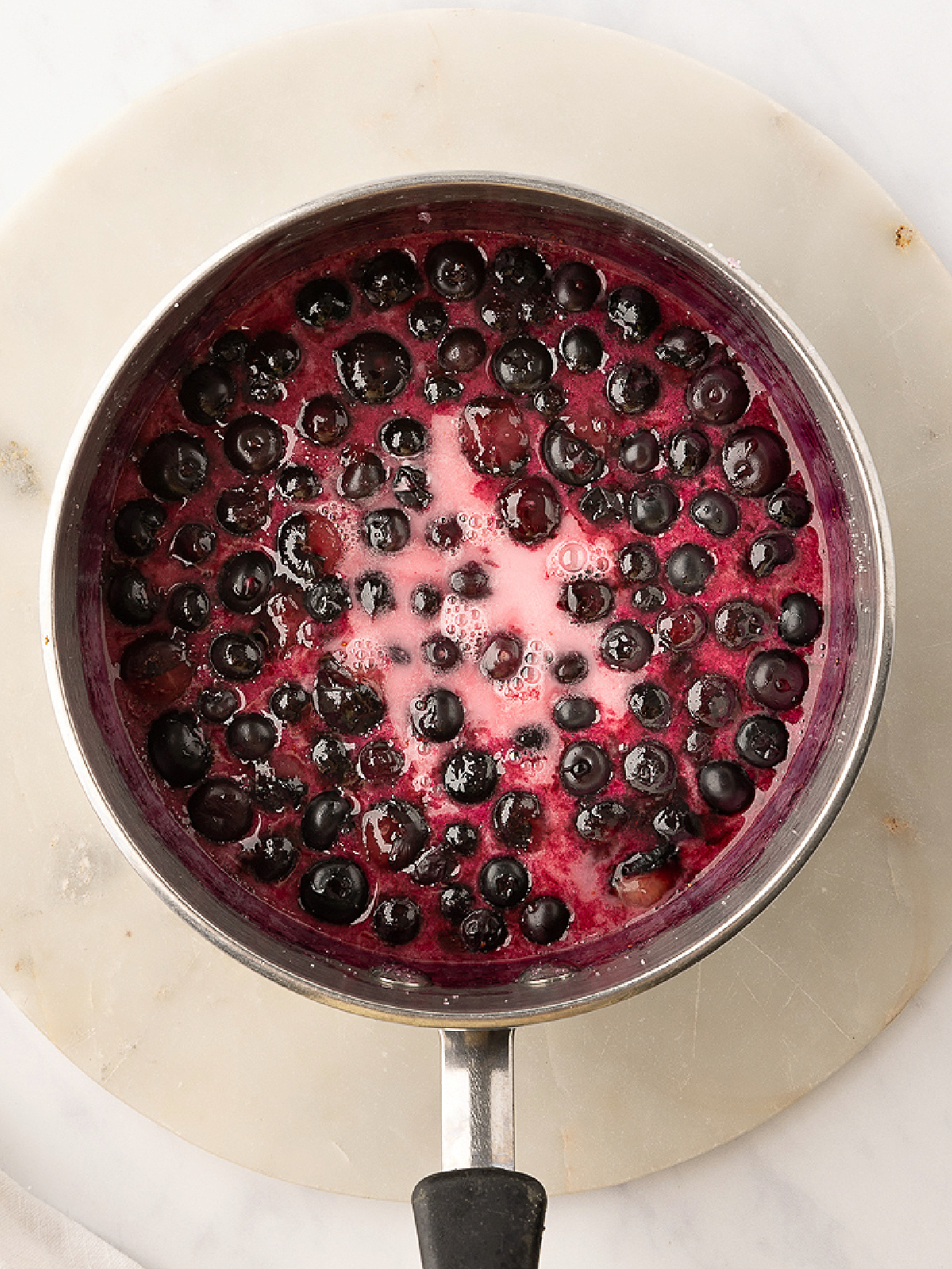 Blueberries simmering in a pot.