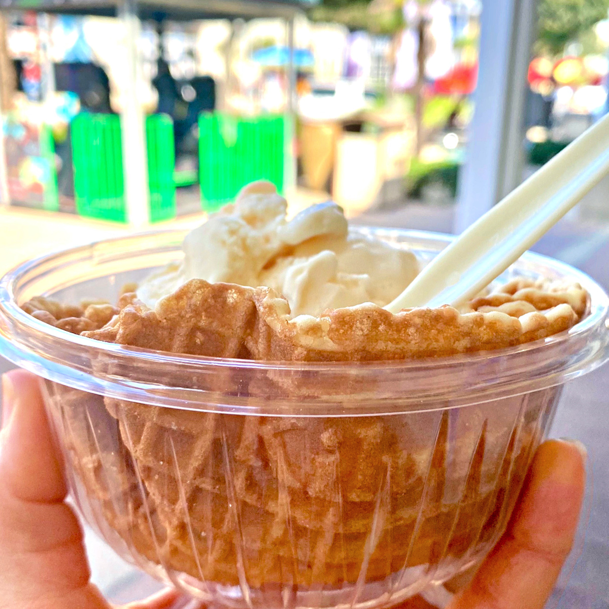 Waffle bowl filled with peach ice cream.