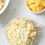 Plate of pineapple coleslaw and small bowl of pineapple chunks.