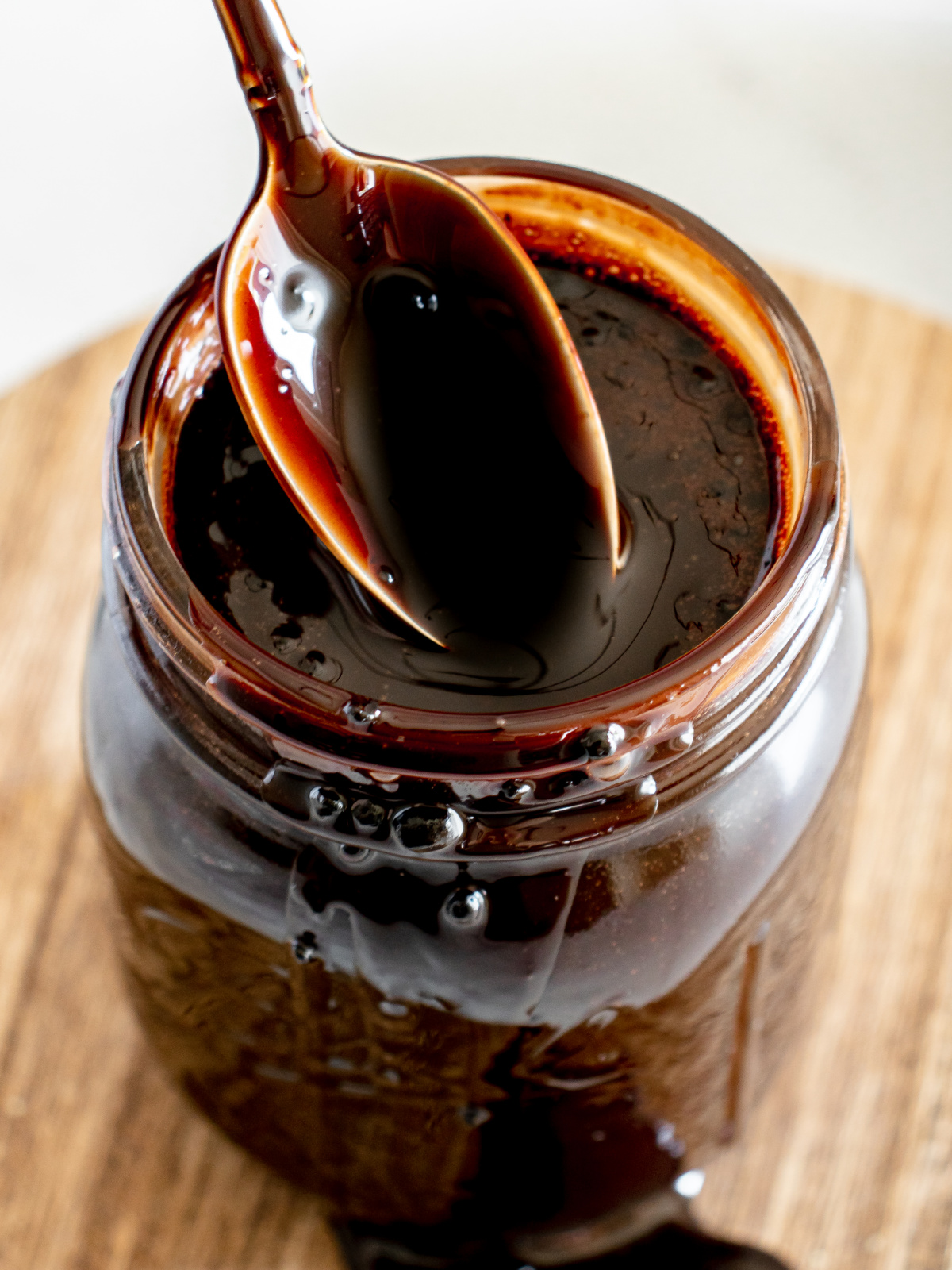 Homemade Chocolate Syrup Spoon of chocolate syrup coming out of a jar.