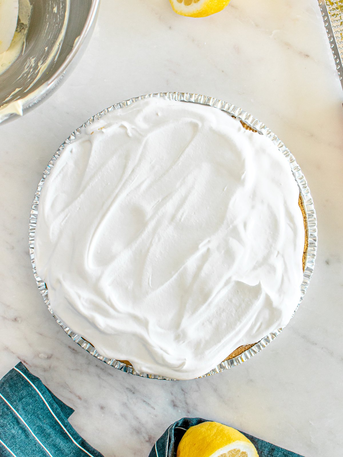 Whipped topping on top of a lemon pie.