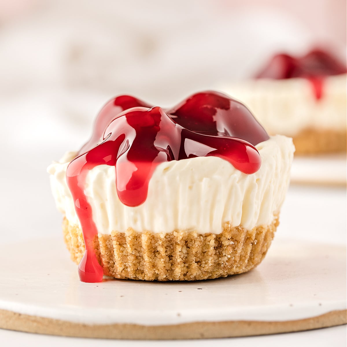 A miniature cheesecake topped with cherry pie filling.