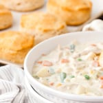 Bowl of chicken pot pie soup and a pan of biscuits.