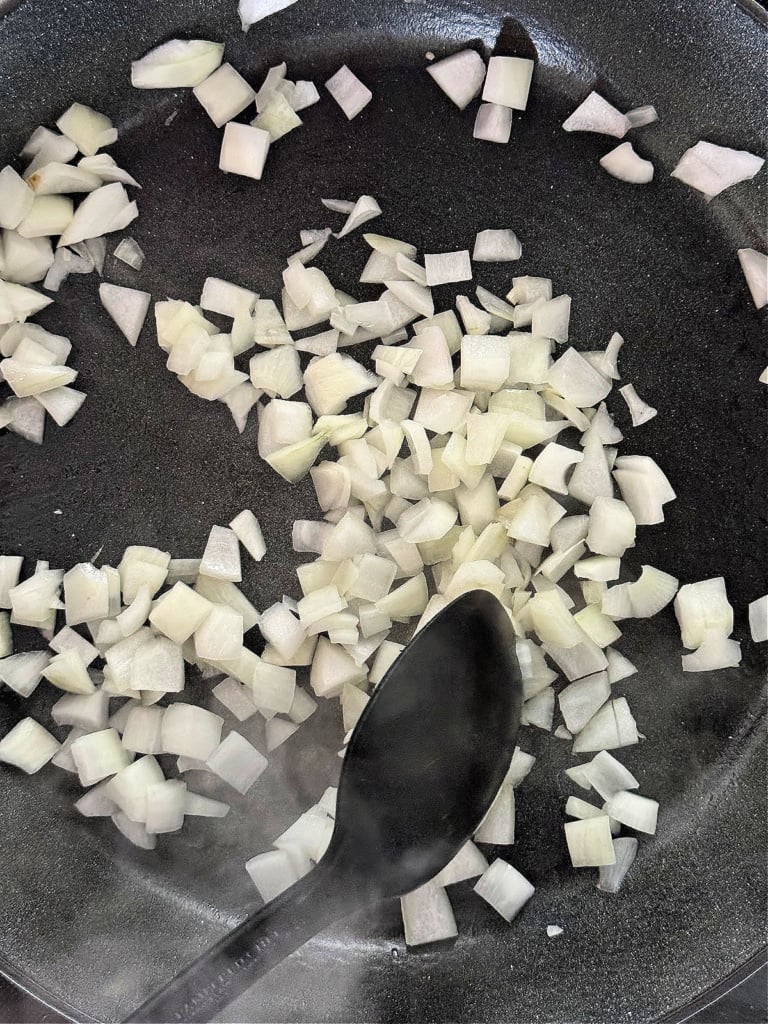 Onions sautéing in a pan.