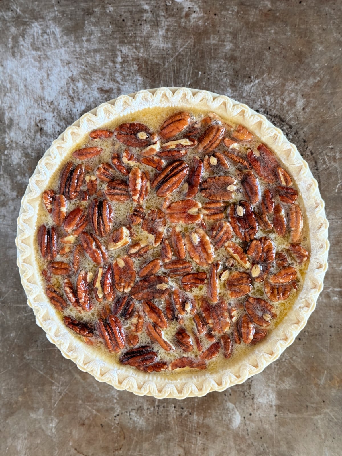 Unbaked pecan pie on a cookie sheet.