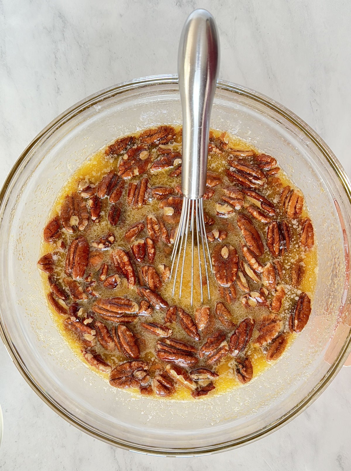Pecans in a bowl with eggs and sugar.