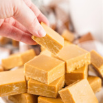 Hand selecting a piece of caramel fudge.