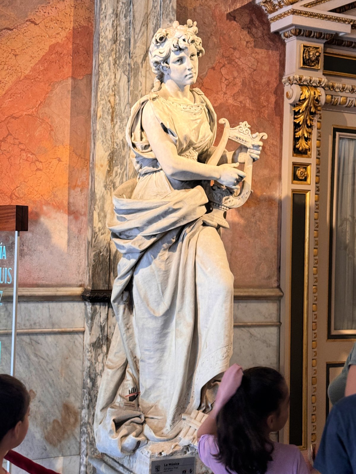 Statue of a woman playing a harp.