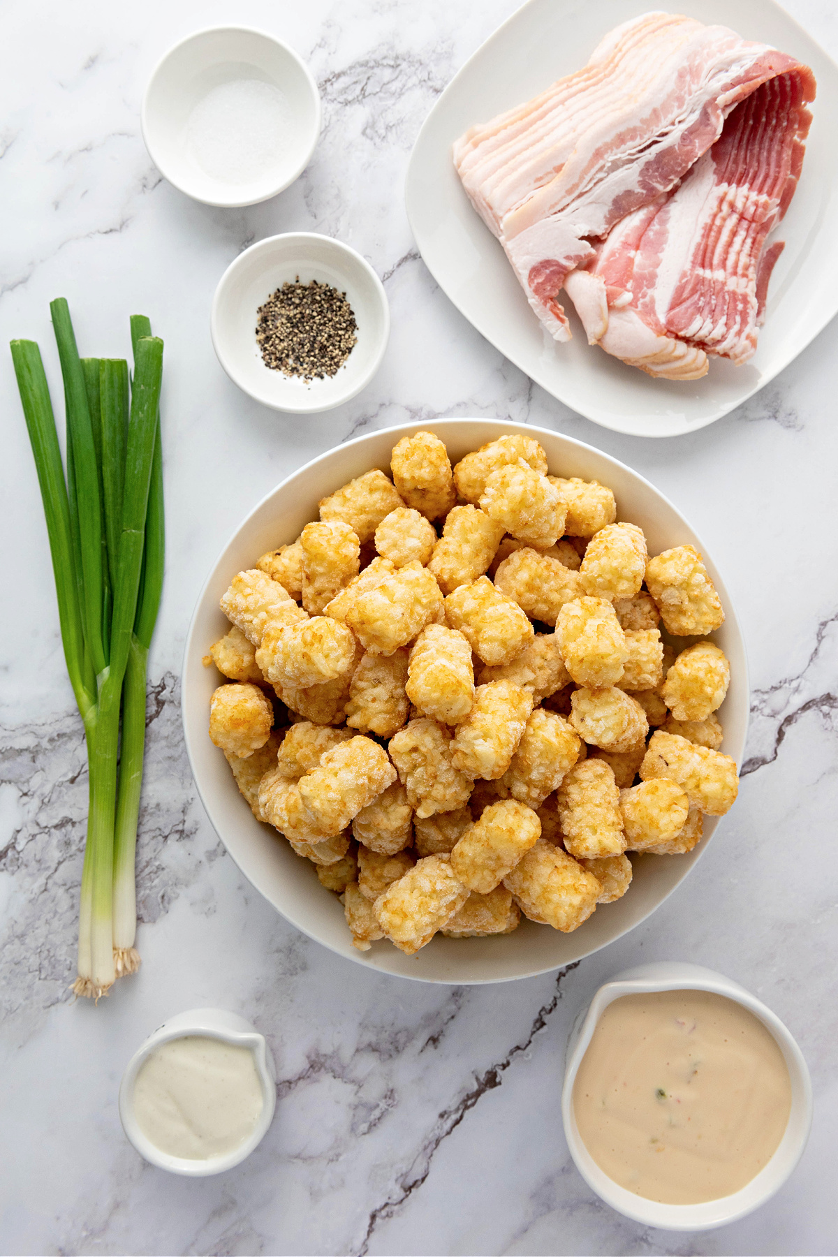 Frozen tater tots, green onions, raw bacon, seasoning, Ranch dressing, and queso.