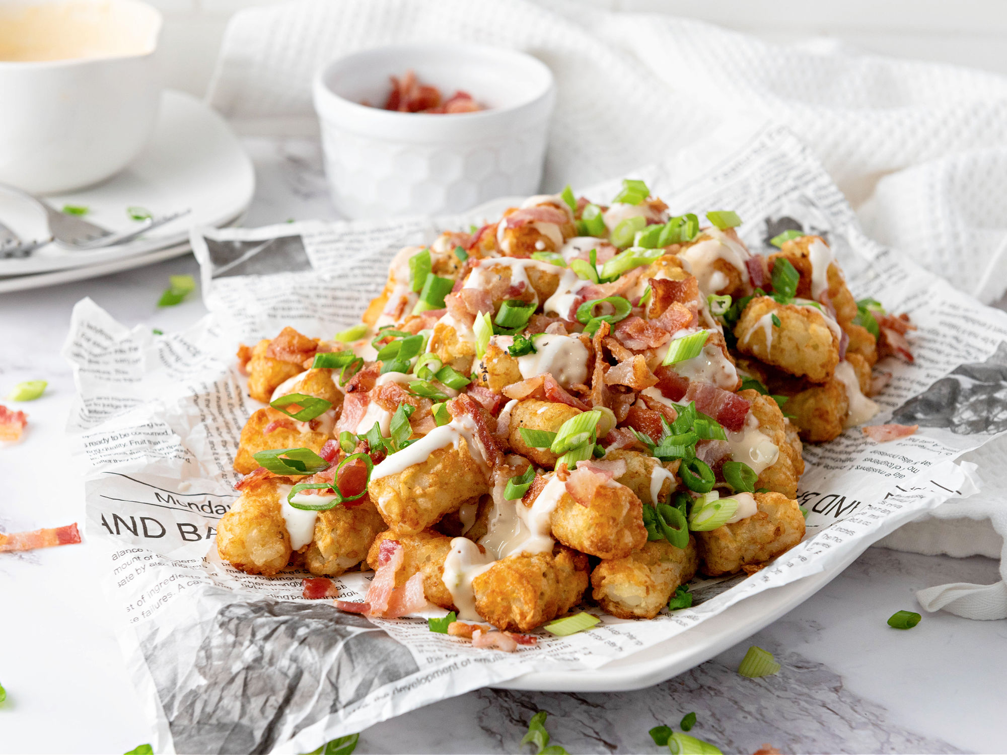 Loaded tater tots with bacon, Ranch, queso, and green onions.