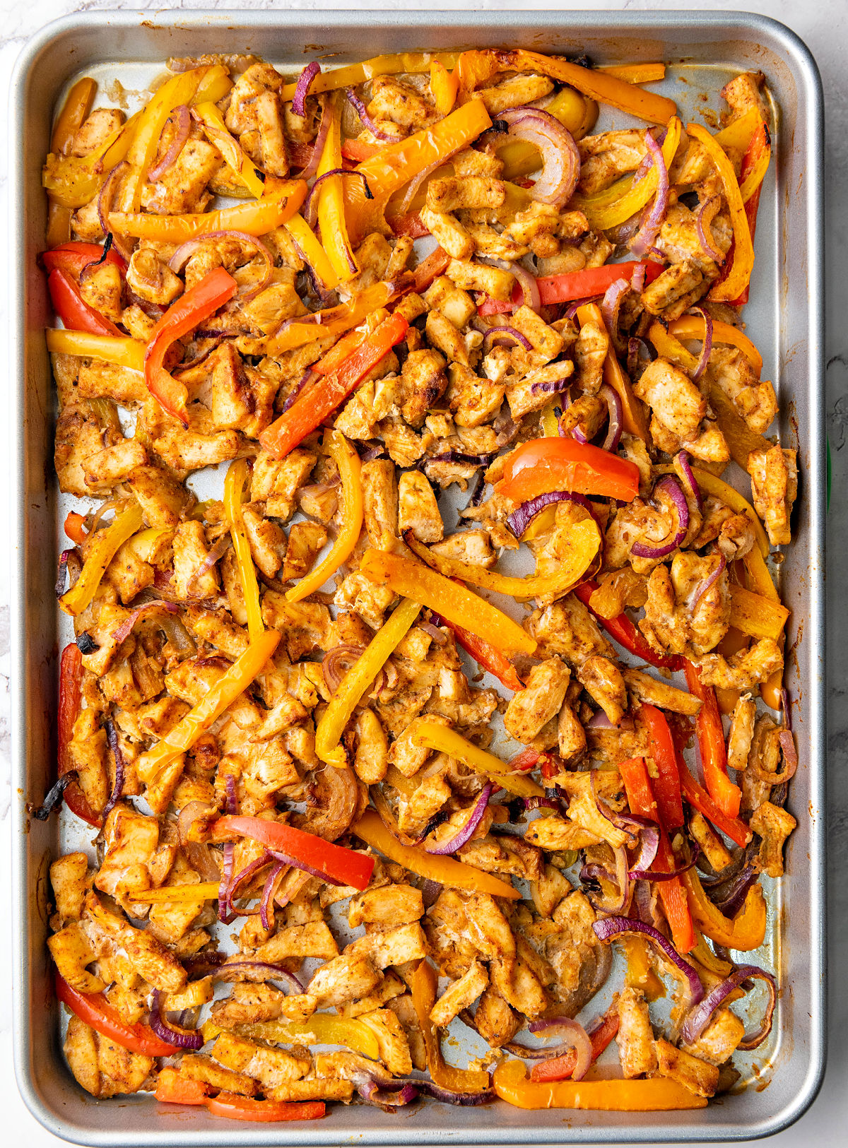 Baked chicken fajitas on a sheet pan.