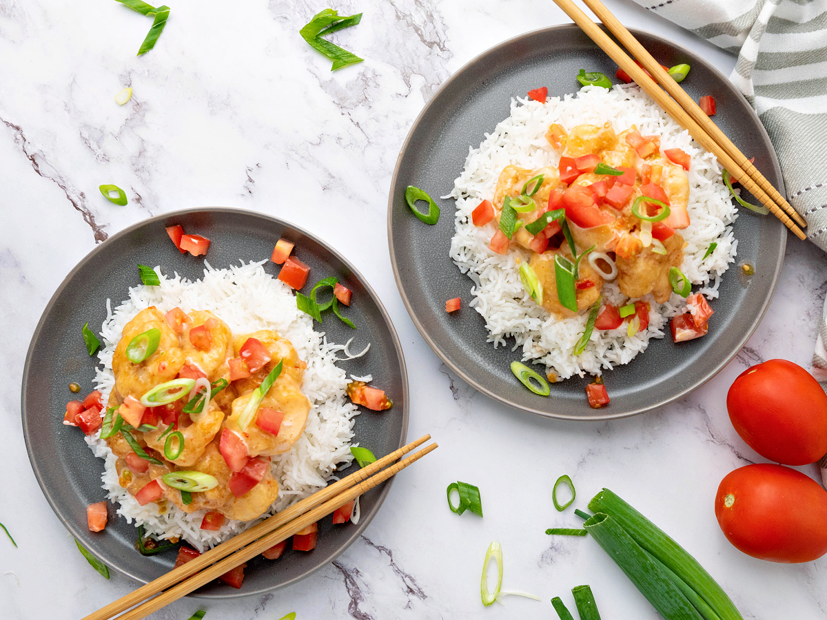 Two plates filled with rice and bang bang shrimp ready to serve.